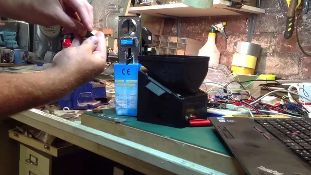 Chris demonstrating the Arduino coin change machine, with the coin acceptor and hopper on the workshop bench